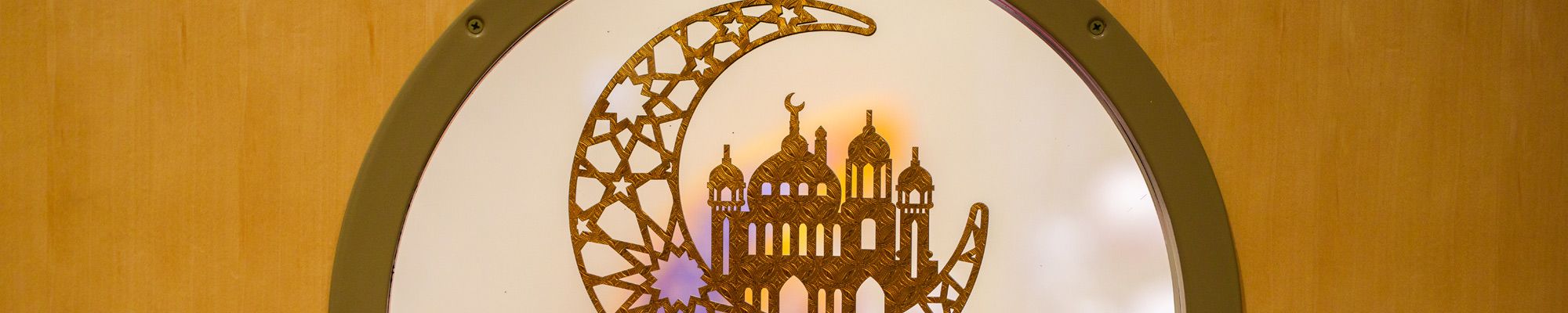 Moon and Mosque pendant hangs in a door window on campus