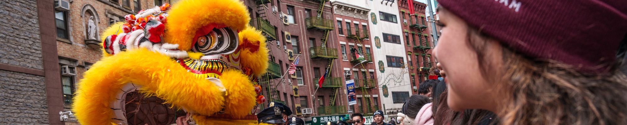 A student looks on at a dragon costume during Lunar New Year festivities