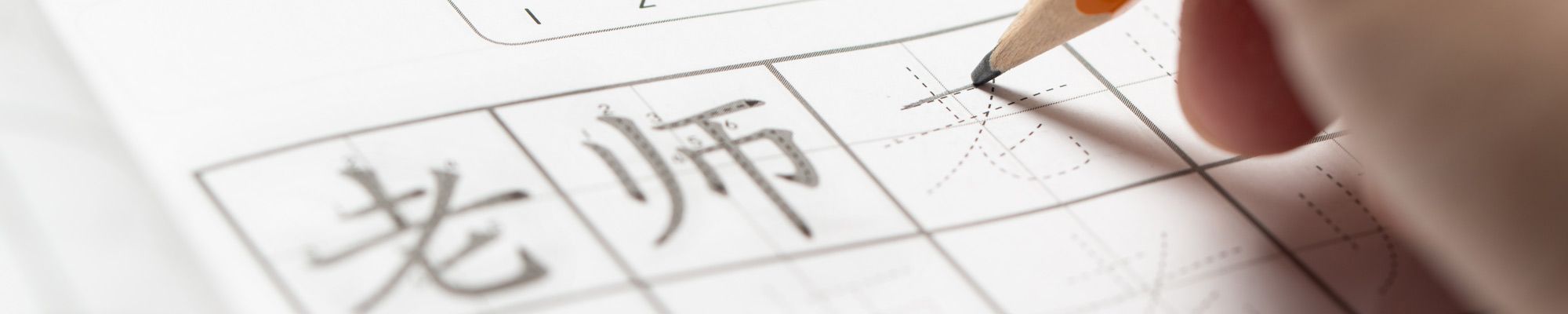 Learning Mandarin concept, learning how to write simplified Chinese word characters, pencil over Tianzi Ge grid paper