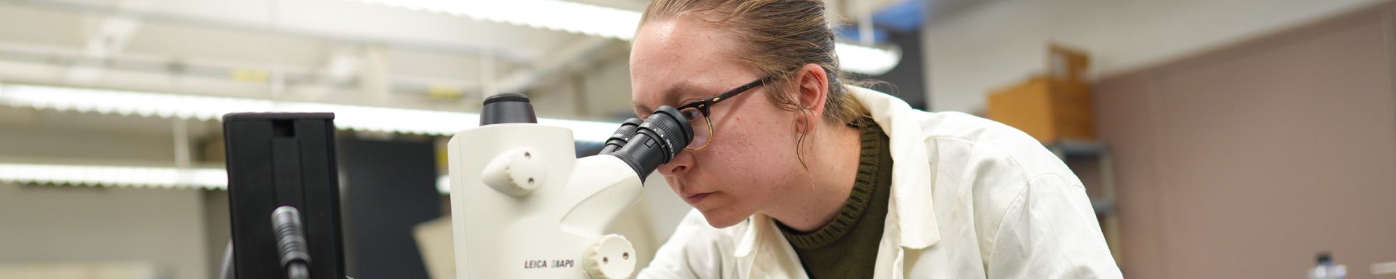 Student looking through a microscope in a lab