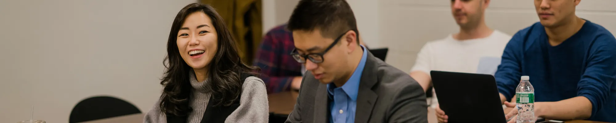 two students sitting in class, one is laughing