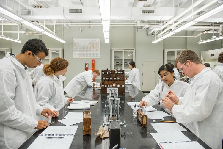 Several students in lab coats in a science laboratory