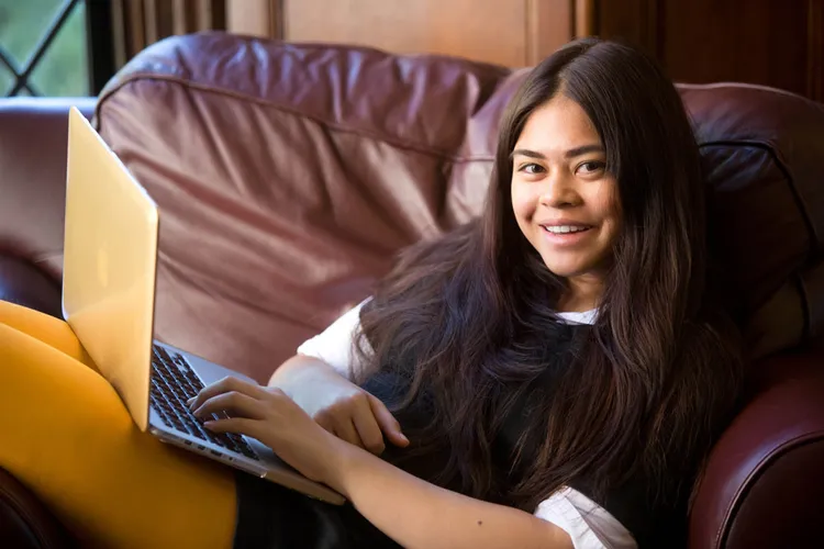 A student relaxes on a couch in Bishops Lounge