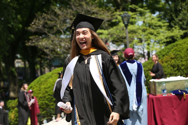 Student smiling and walking at Commencement