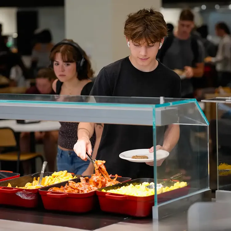 Student serving himself at a breakfast buffet