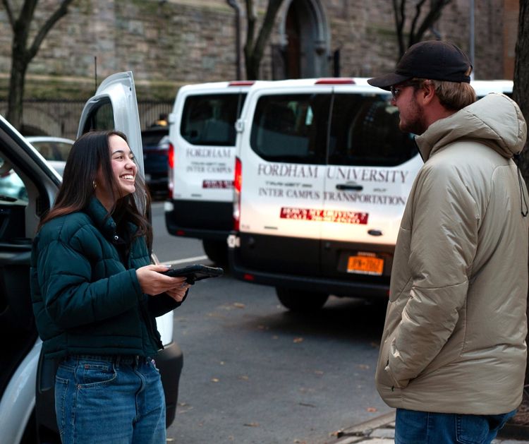 Student Boarding a passenger onto a Ram Van at Lincoln Center