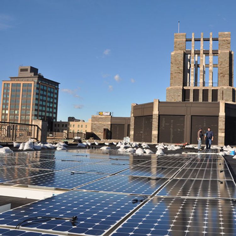 Installing solar panels on top of Walsh Library on the Rose Hill campus