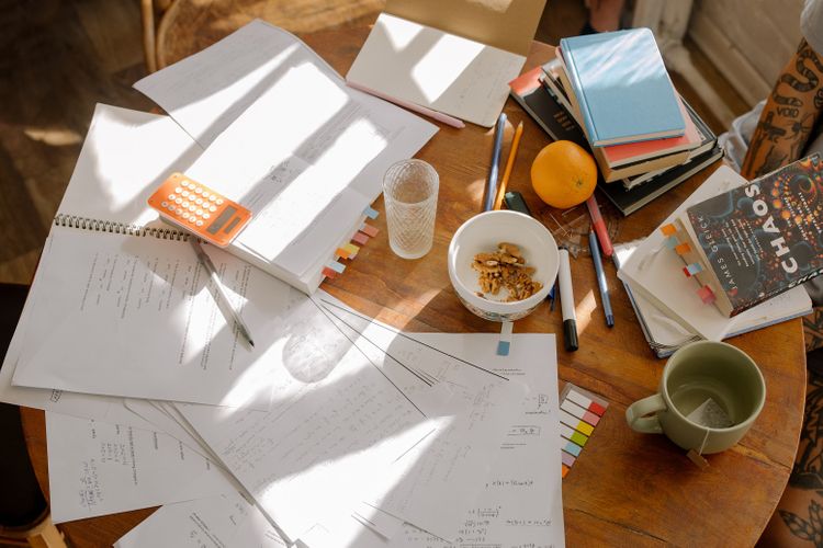 Snacks on table while doing financial calculations with reference books