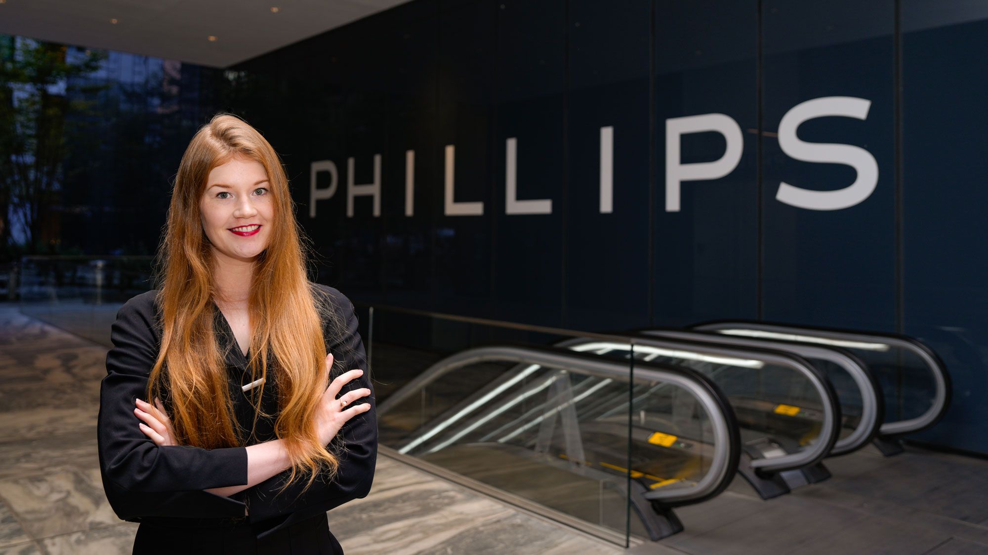 A woman poses in front of an auction house