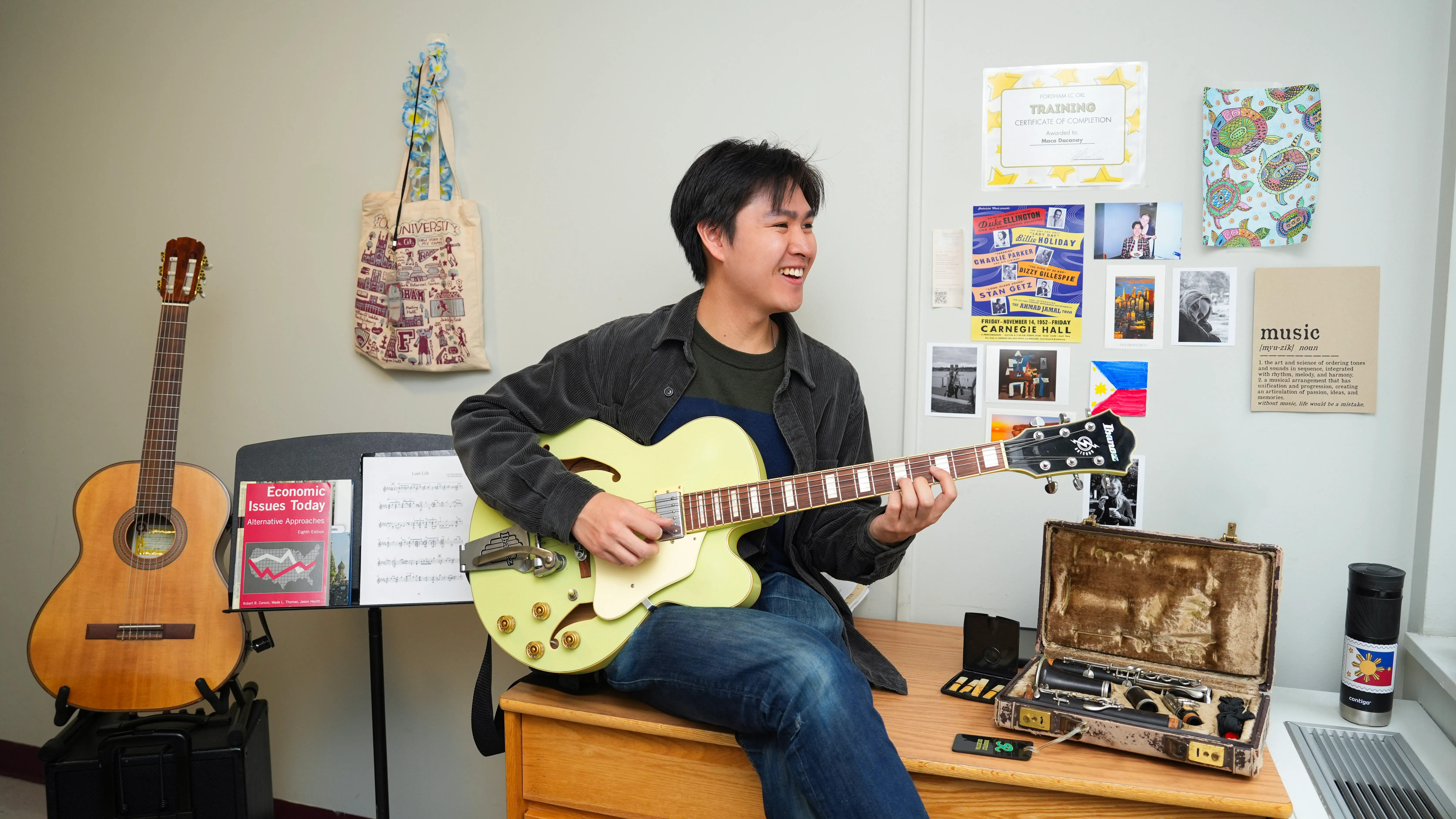 Maco Dacany plays guitar in his dorm room.
