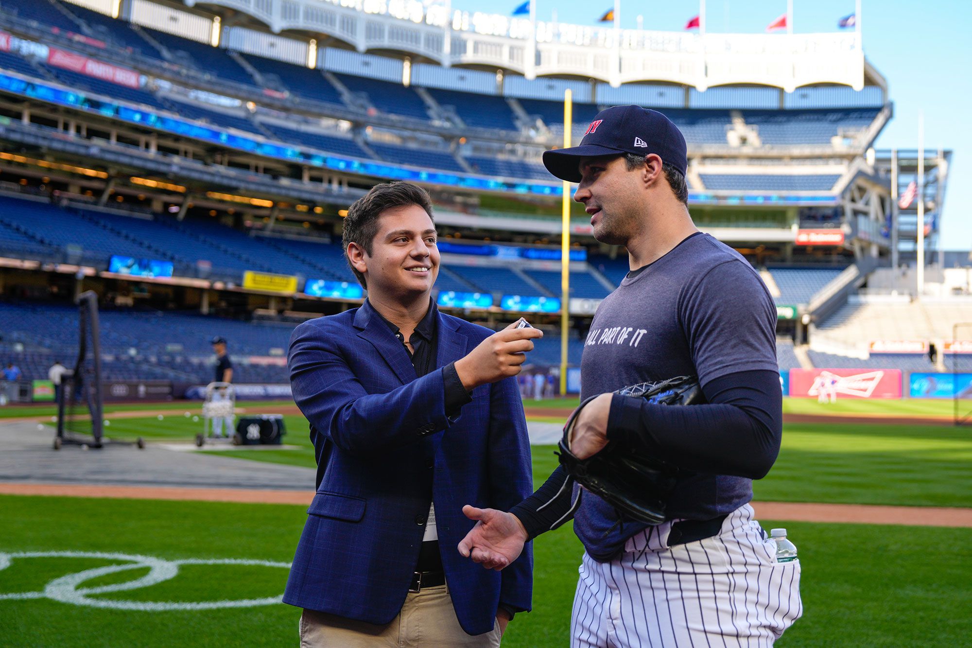 A student interviews a member of the New York Yankees on the field.