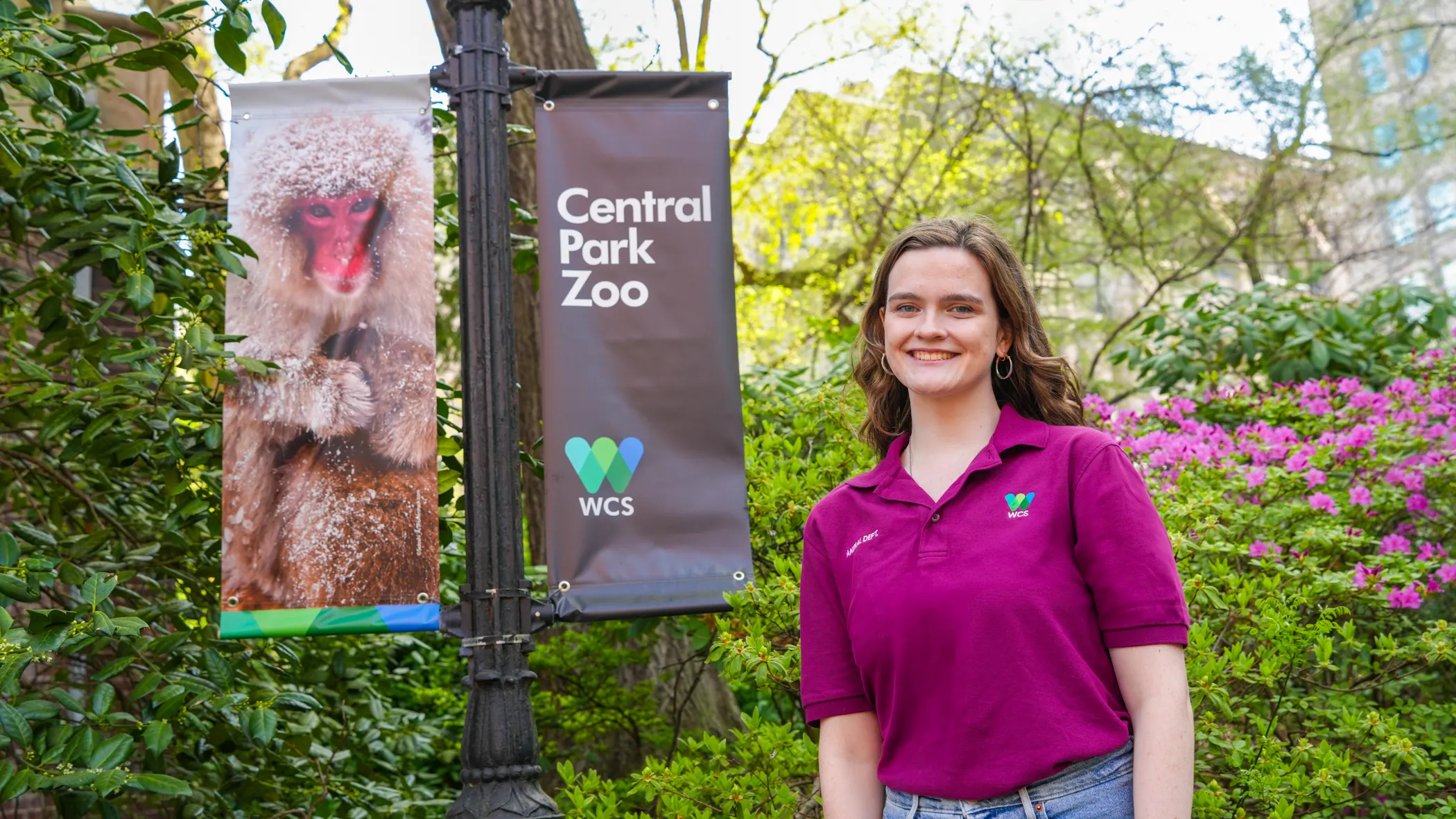 Shannon standing next to a Central Park Zoo/monkey sign