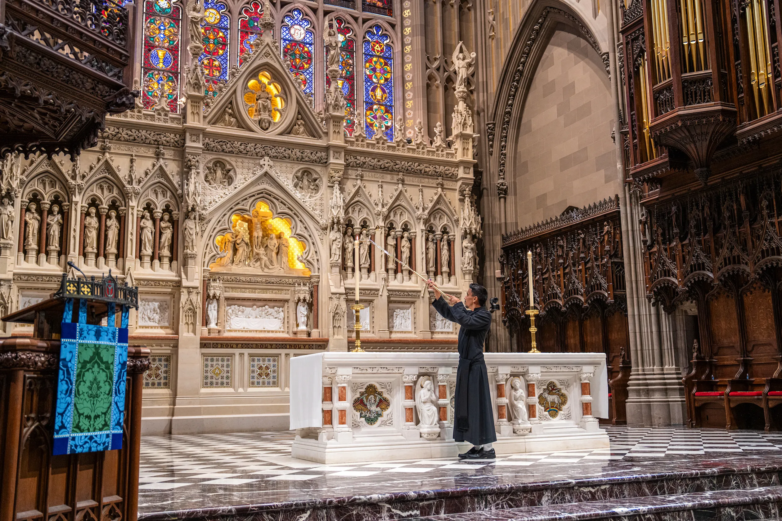 John Garza lights a candle on the altar of Trinity Church