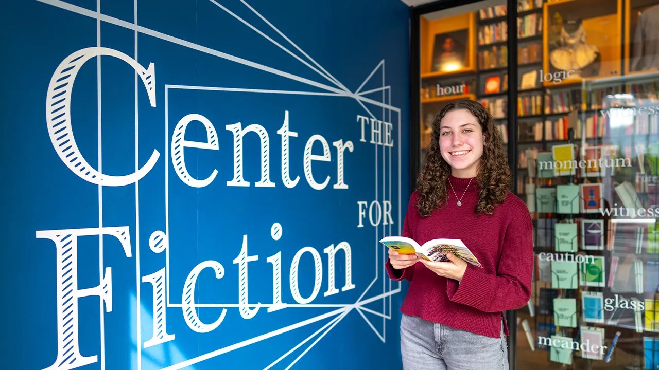 Madison Cossaboom standing in front of Center for Fiction signage
