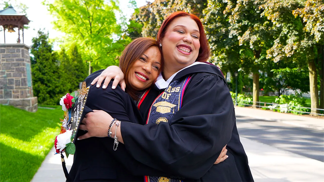Jennifer Espinal hugs her mother at Fordham Commencement 2024.