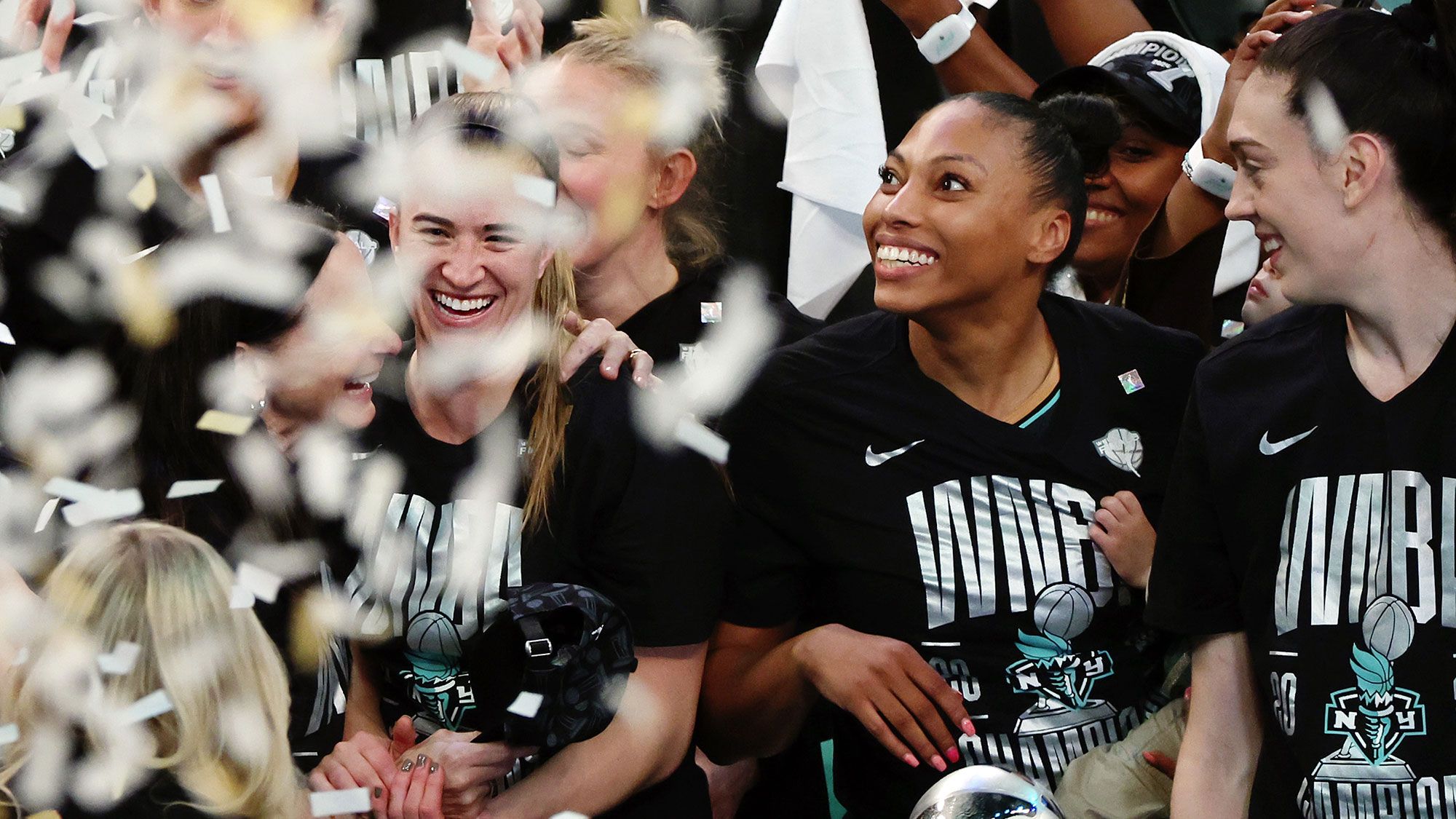 WNBA players celebrate on the court after winning a championship