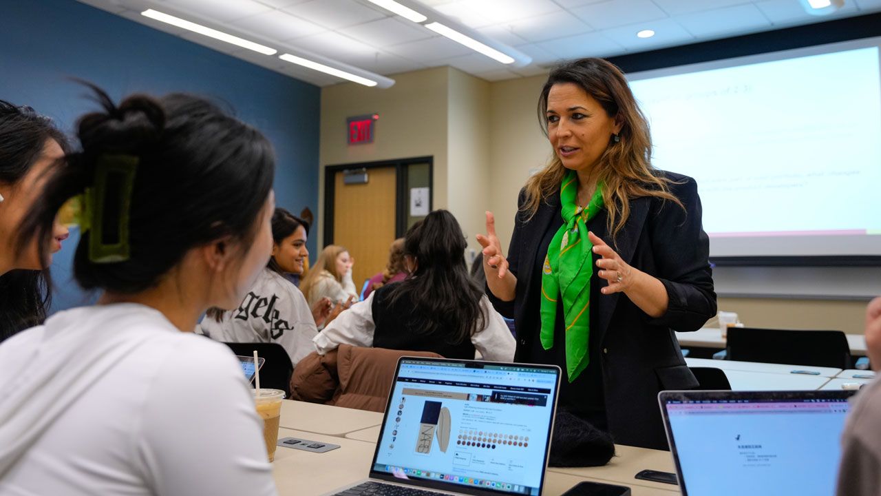 A professor talks with students in their classroom