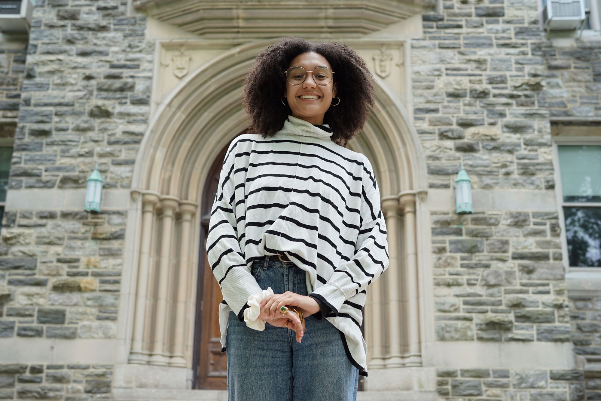 A student poses outside of a building on campus
