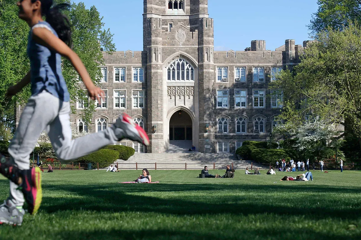 Student running in front of Keating Hall on Rose Hill Campus