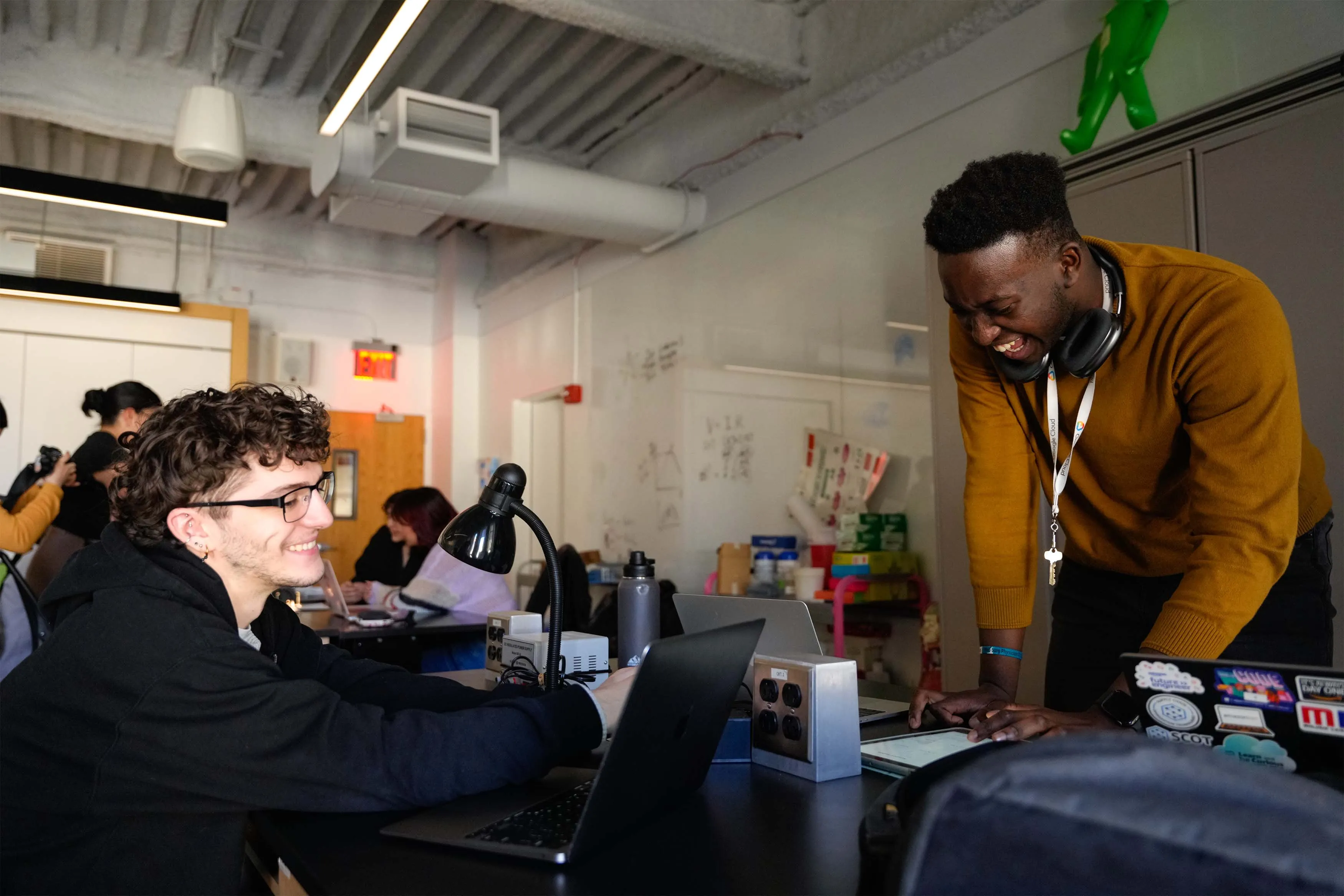 students looking at laptops smiling
