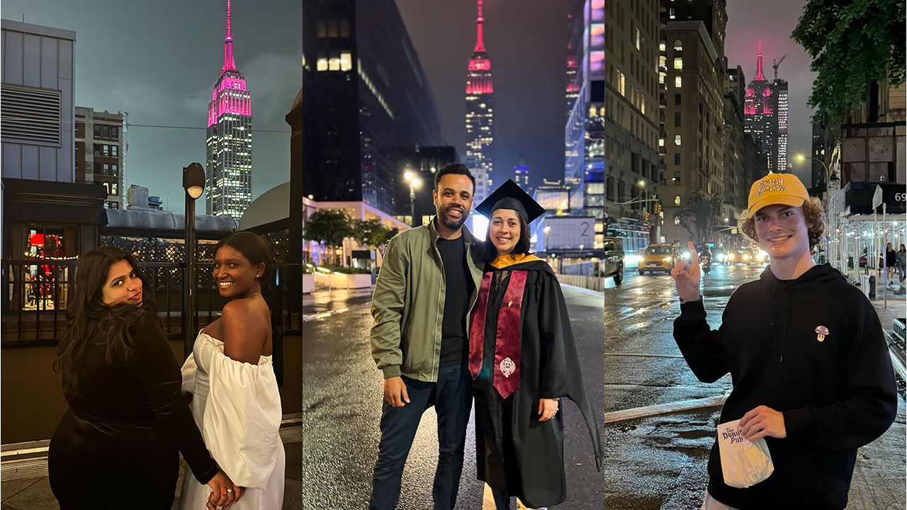 Students pose with the Empire State Building lit up maroon in honor of commencement