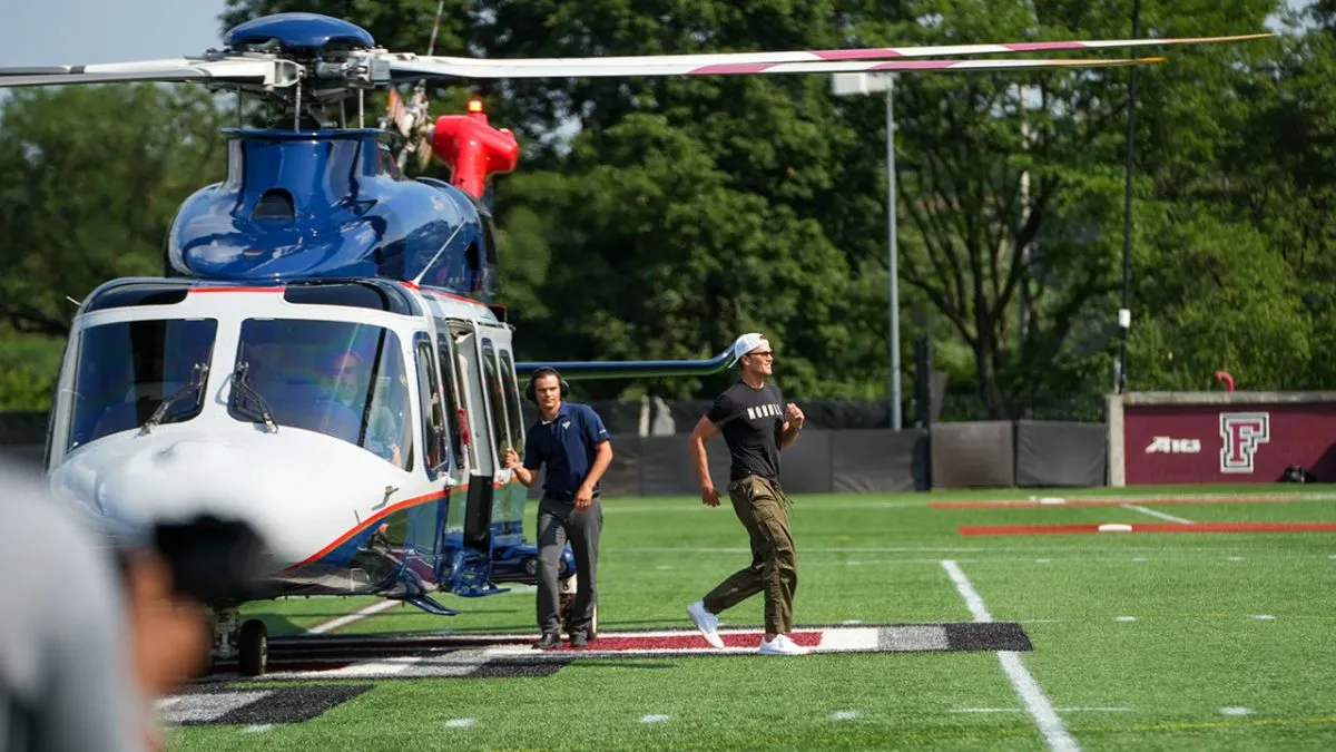Tom Brady exits a helicopter that landed on Fordham's football field