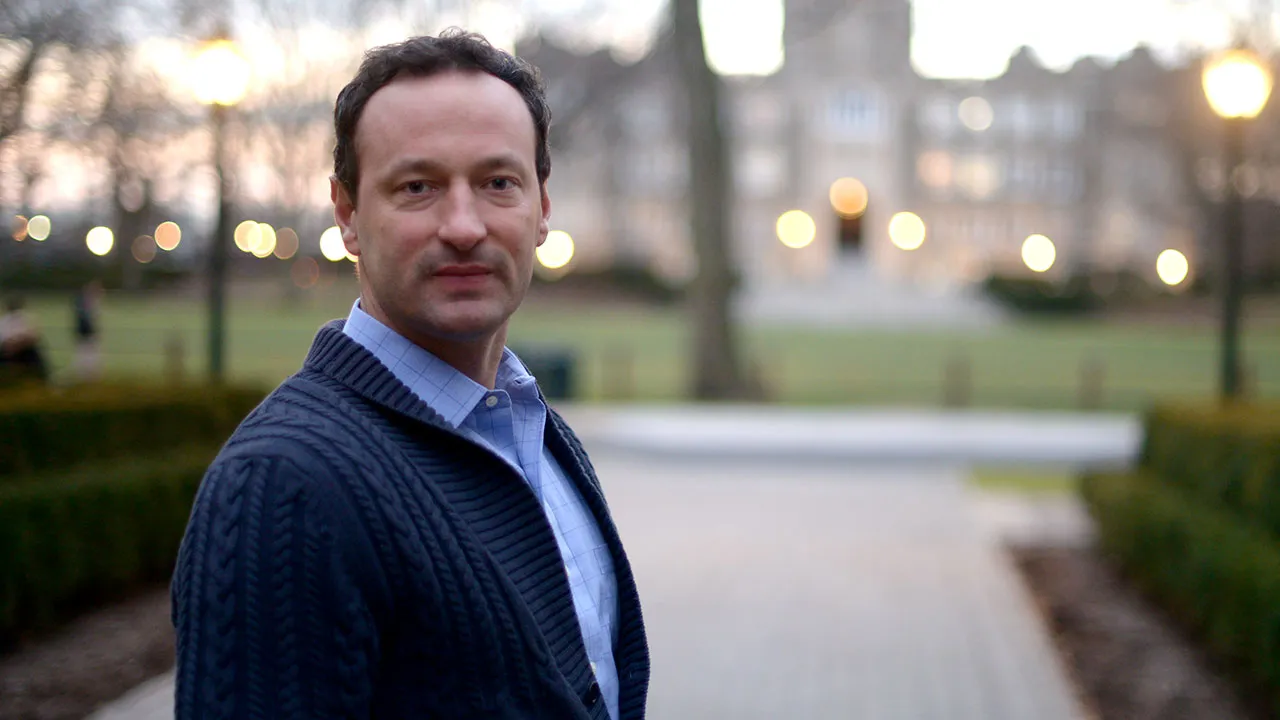 Marc Conte poses in front of Keating Hall on the Rose Hill campus