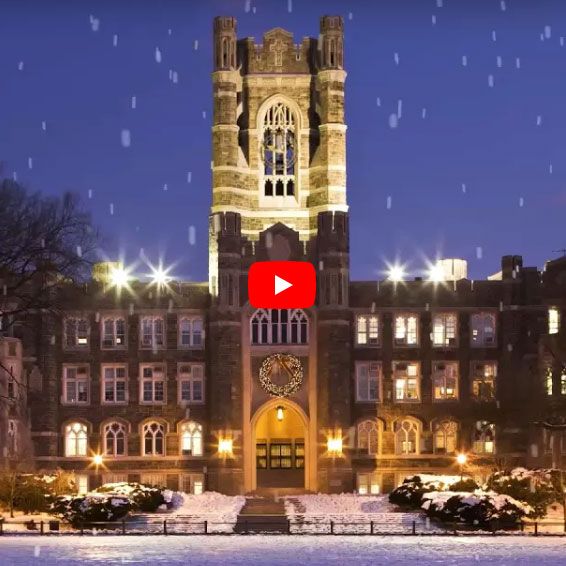 Keating Hall at night with a play button