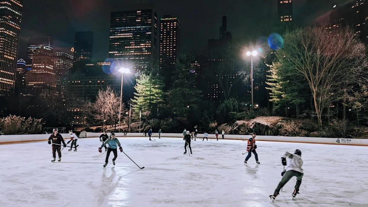 A group of people playing ice hockey on Wollman Rink in Central Park