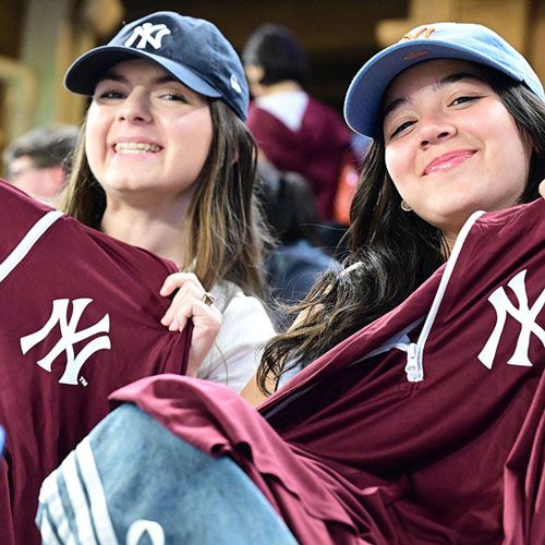 Students hold up Fordham Yankees jersey at Fordham Night at Yankee Stadium