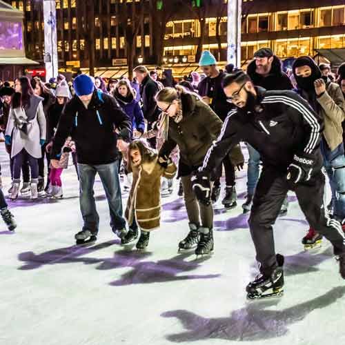 People ice skating at night in Bryant Park