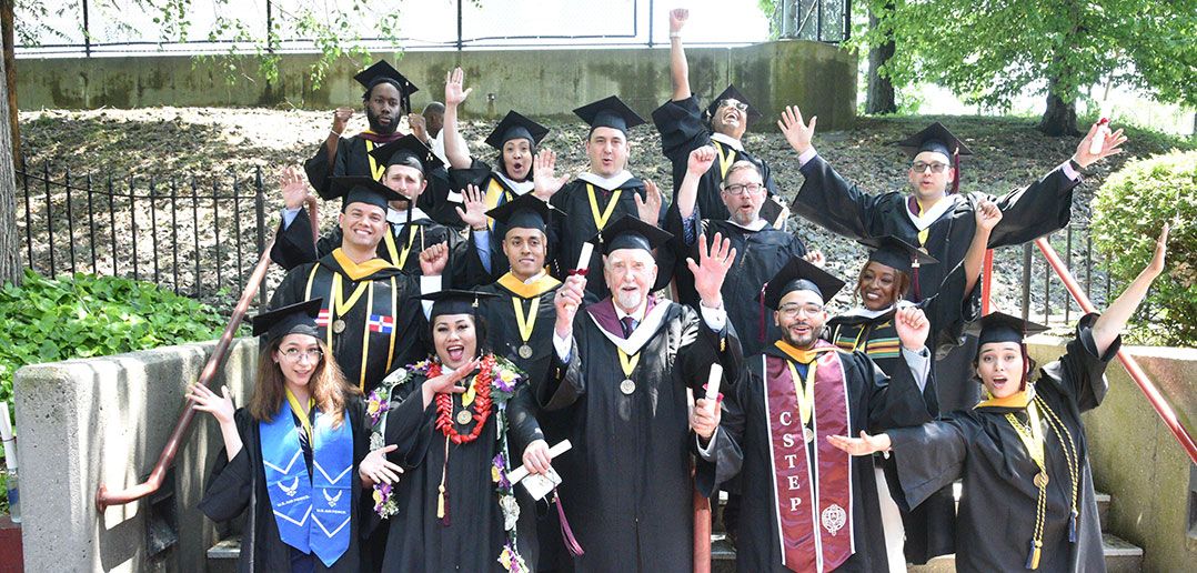 A group of graduates pose for a photo after University Commencement at Rose Hill Campus