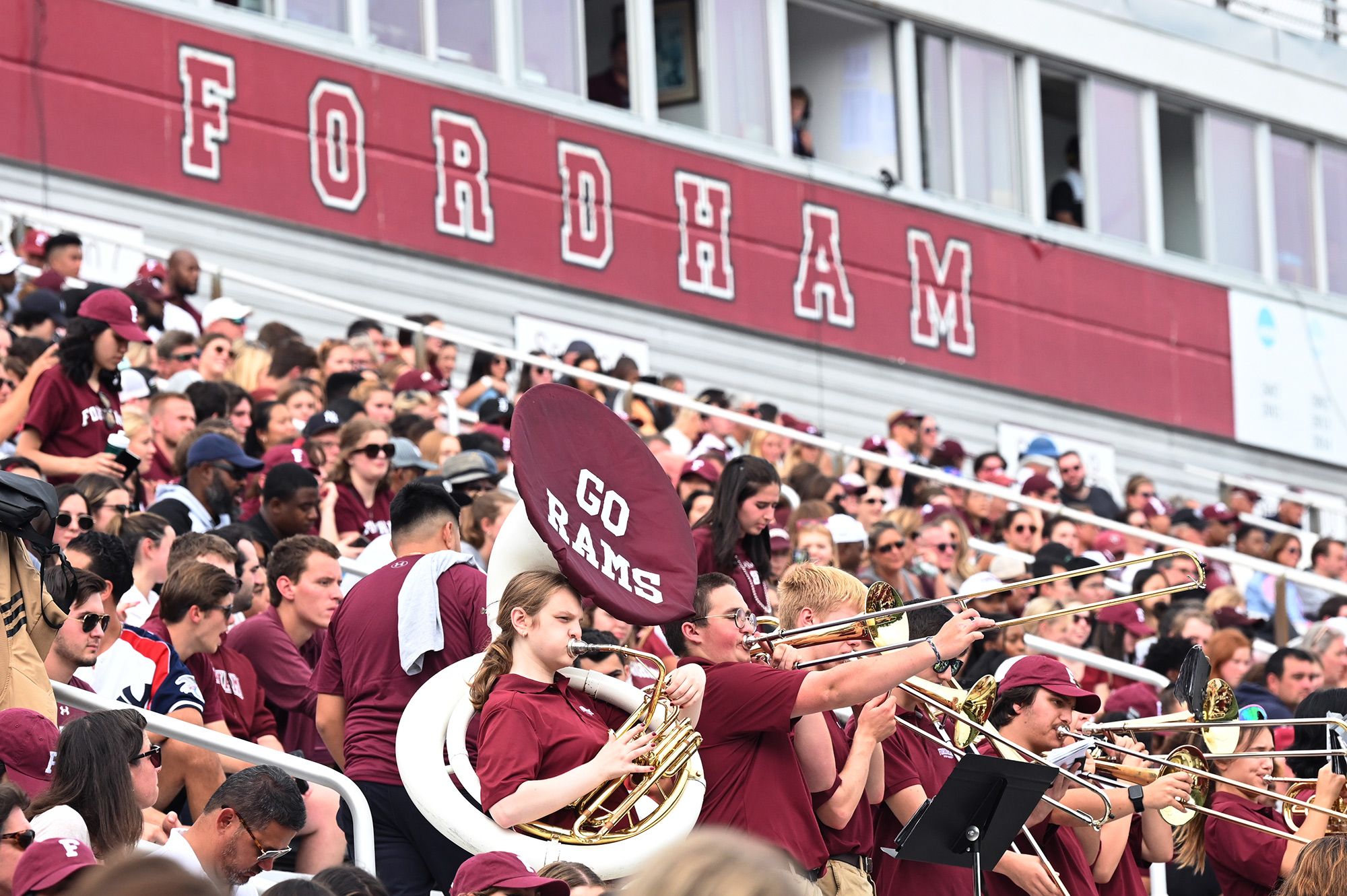 Fordham students and band members standing in the stands at a Fordham football game
