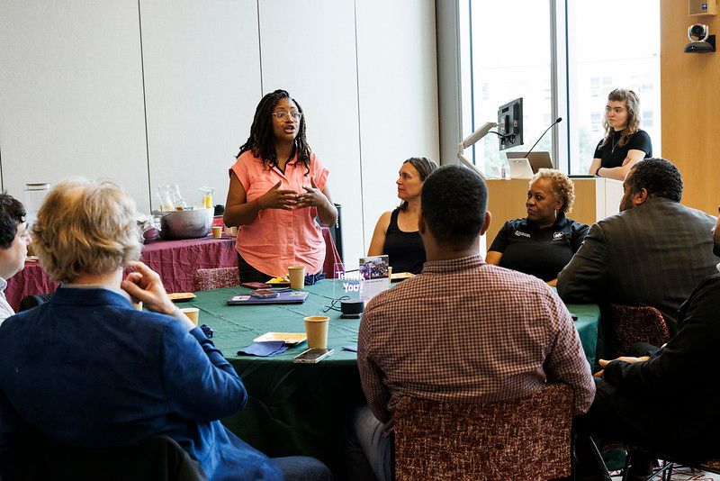 A speaker presents to a table at Rooted in Gratitude: FIC Partnership Breakfast 2025