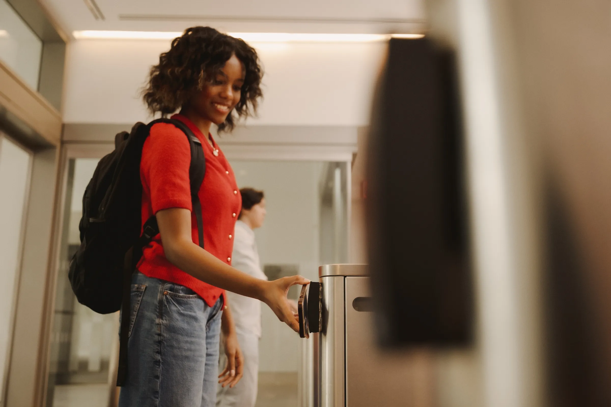 A student tapping their electronic ID at a reader