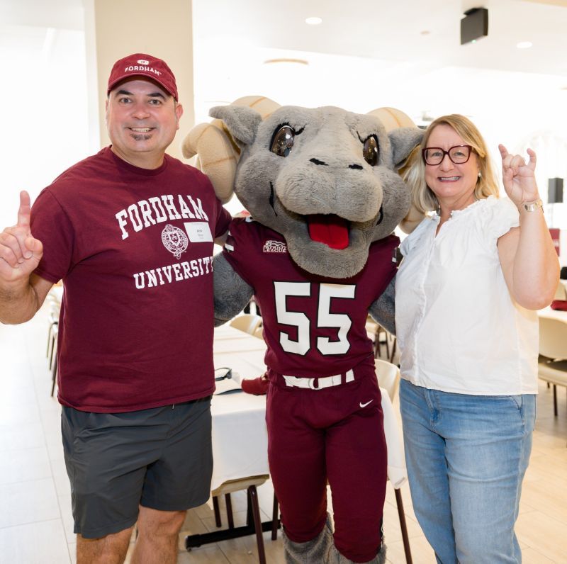 Parents smiling and posing with Ramses in front of white background
