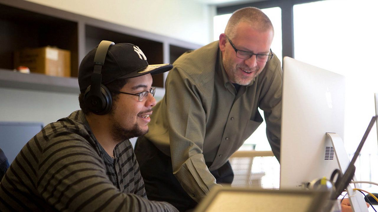 Professor and Student looking at a MAC