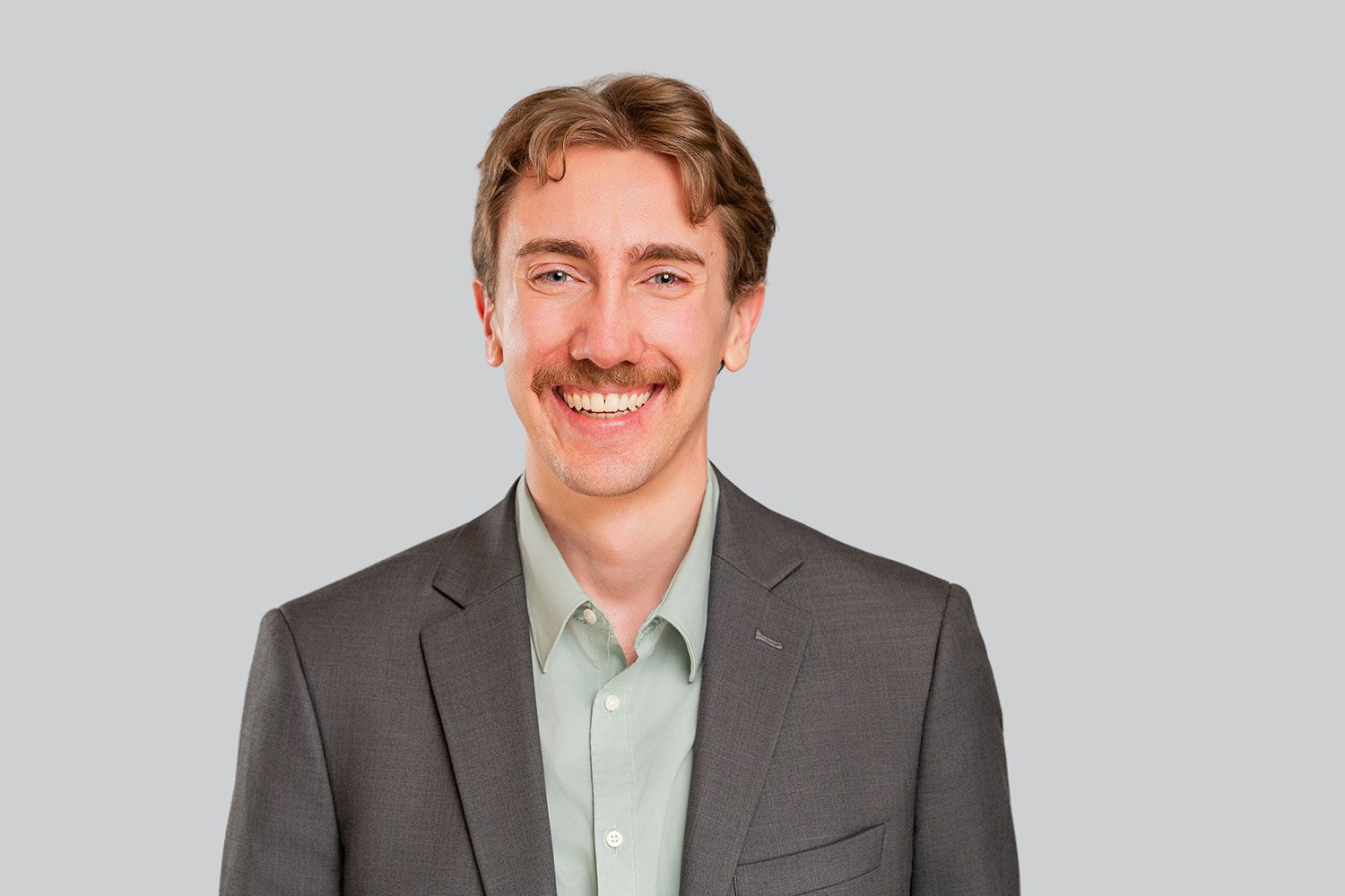 Alex Gruber standing in front of a white background
