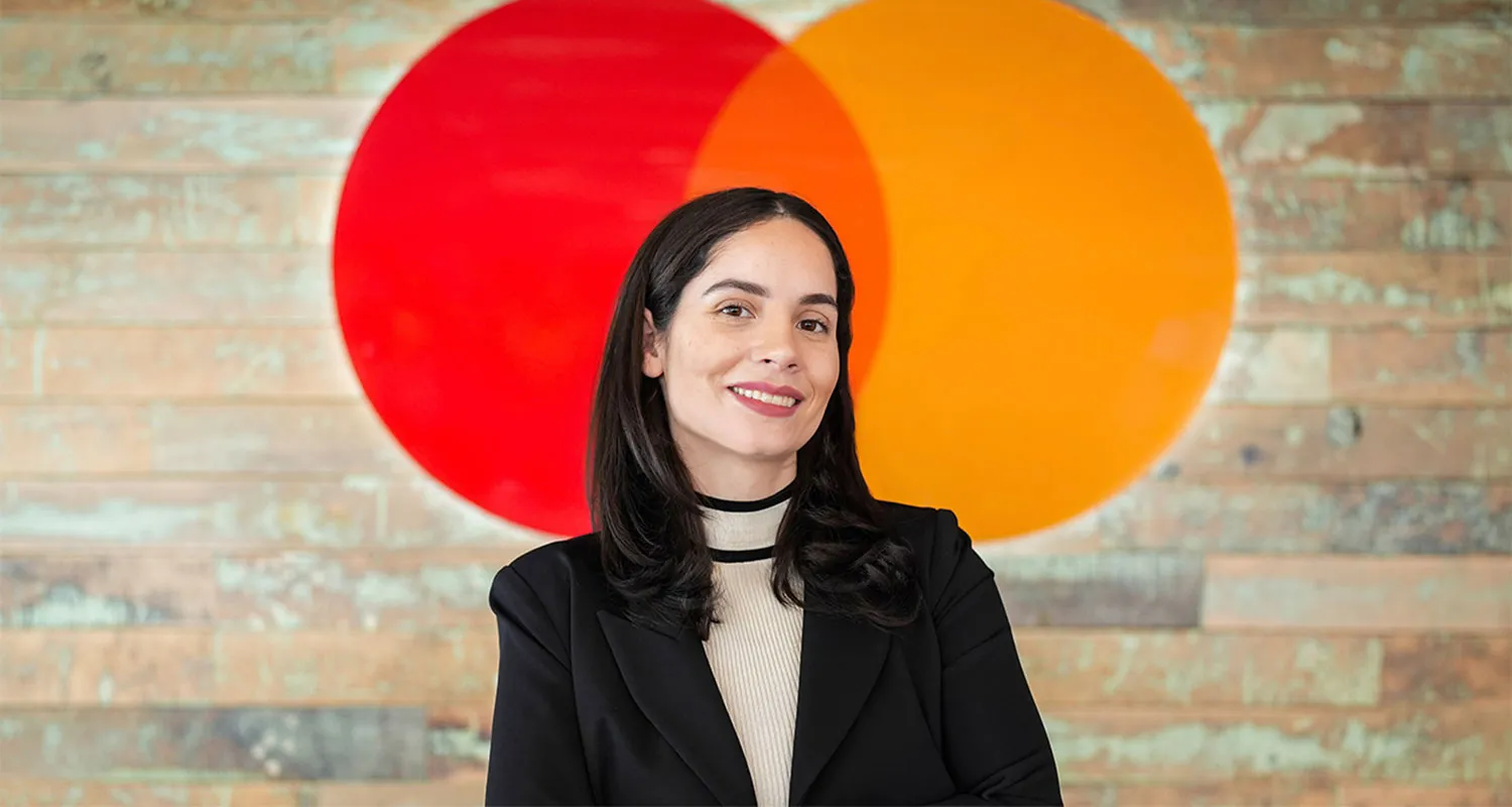 Indhira Jaquez Torres standing in front of Brick wall with Orange and Red Circles