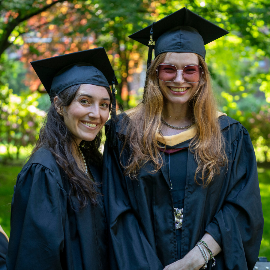 Fordham MSW student Frankie Heppell stands next to a classmate on graduation day at Fordham's Rose Hill campus and smiles.