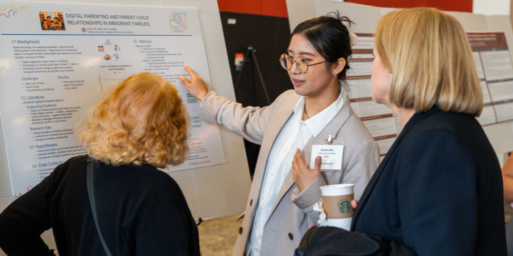 A student showcases their research to two University professors.