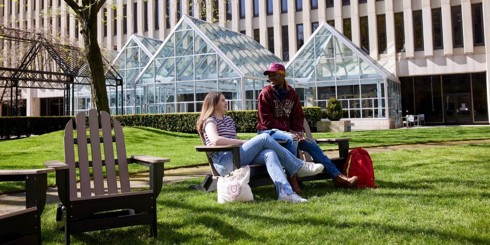 Fordham students sitting in the Fordham Lincoln Center campus courtyard