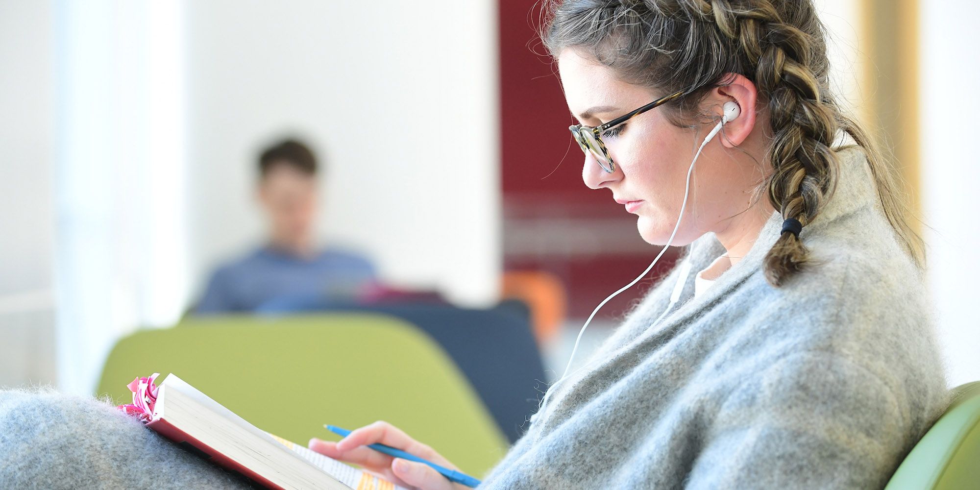 female student reading with glasses and earphones 2000Wx1000H