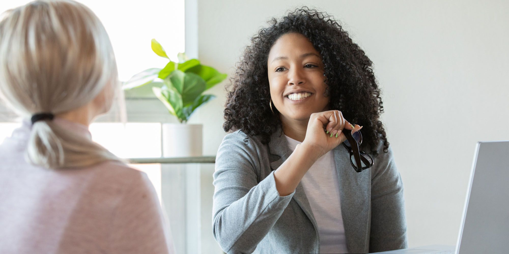 two females talking diverse holding glasses 2000Wx1000H