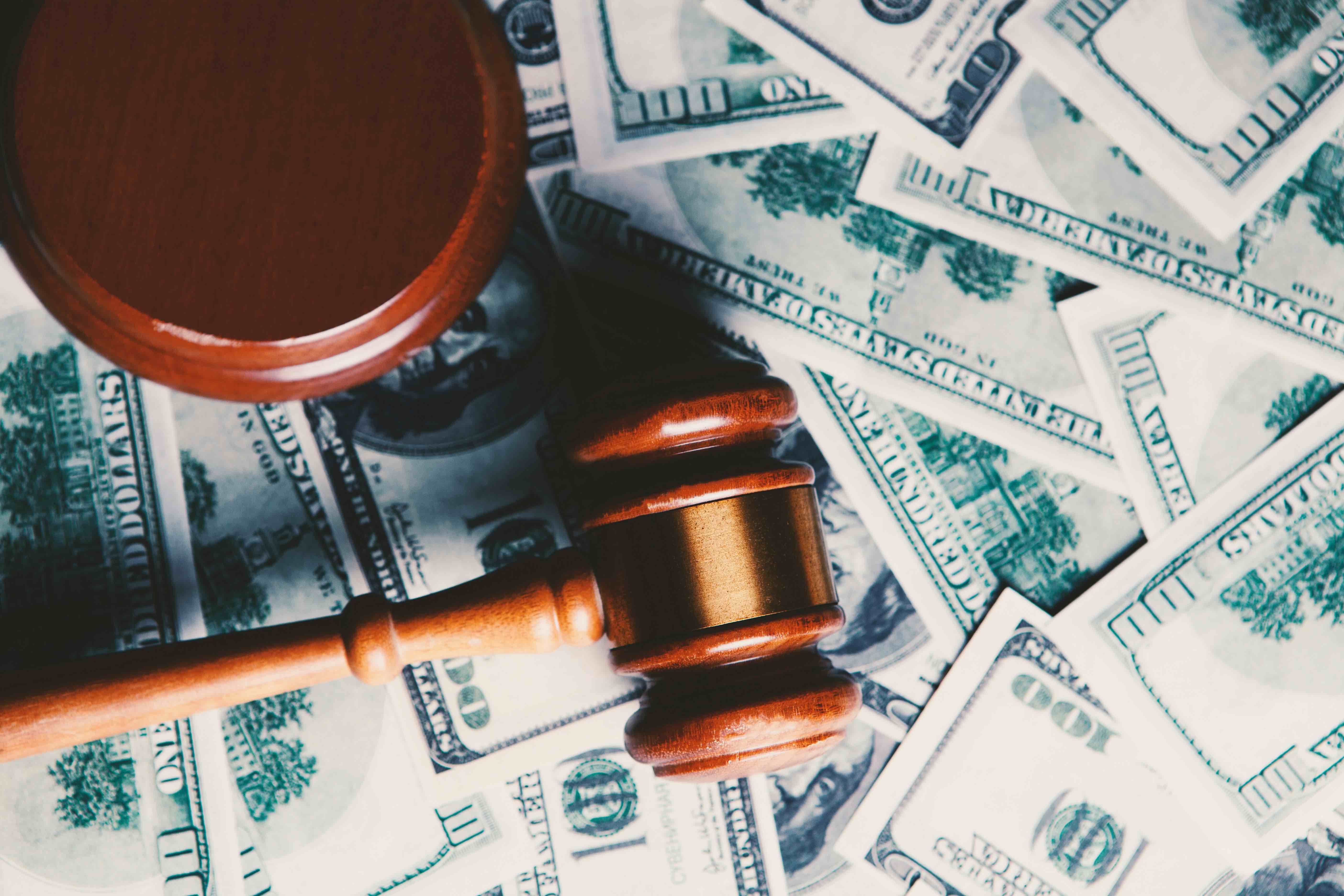 A gavel on top of dollar bills.