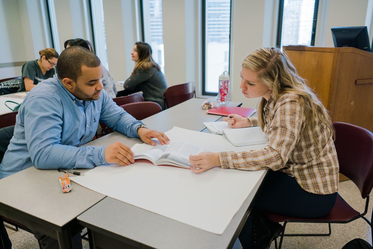Graduate students work together in class
